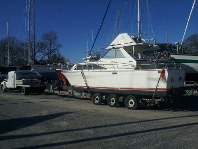 1972 Trojan F31 on trailer being hauled by a Chevy 5500